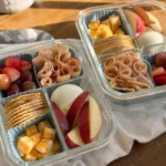 Adult lunchable bento box meal prep with protein, cheese, crackers, and fresh veggies