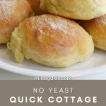 No-yeast quick cottage cheese rolls, golden and dusted with flour, on a white plate