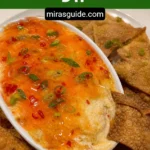 Crab rangoon dip in a baking dish surrounded by fried wonton chips